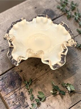 A Fenton Silver Crest milk glass bon bon dish with a ruffled edge.